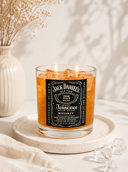 Jack Daniel's whiskey candle on a decorative plate with a neutral background